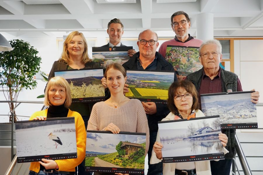  – Bei der Kalendervorstellung im Rathaus. BM Björn Steinbach (oben links), Drucker Jürgen Schweikert (Mitte) und Mitglieder des Fotoclubs. Foto: G. Döttling